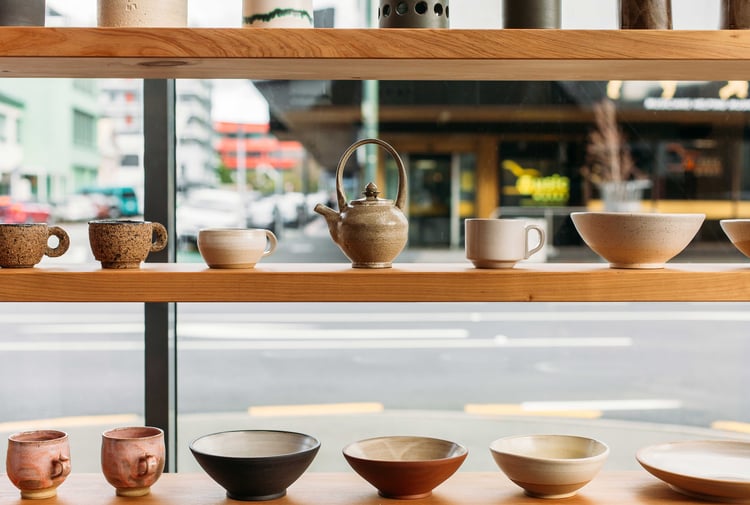 Ceramics on a shelf next to a window looking out towards a Wellington street.