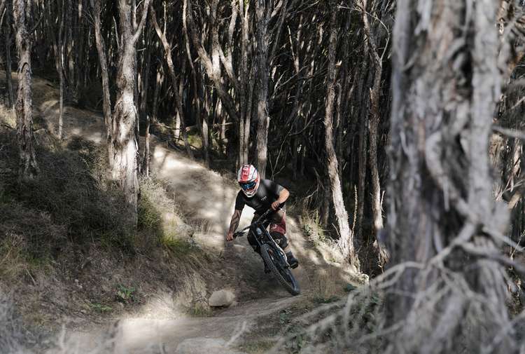 Man riding downhill through forest at Middle Hill MTB.