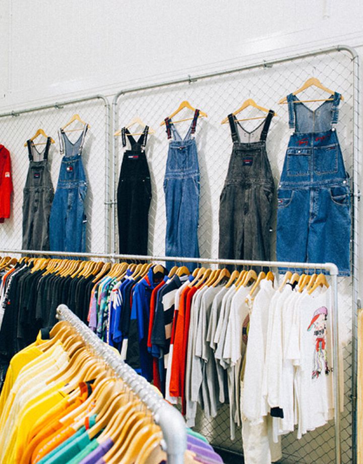 Denim overalls and hats on a wall at Emporium Vintage Boutique Wellington.