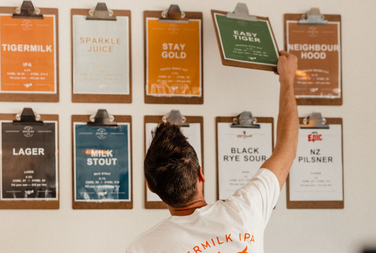 A man organising beer signs inside Brave Brewing Hastings.