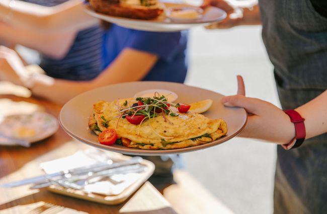 Person holding a plate with an omelette at Alberta's, Māpua Wharf.