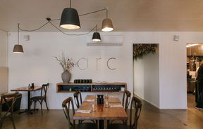 Dining room with wooden table and chairs at arc, Wānaka.