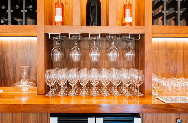Glasses and bottles of wine on display at a bar.