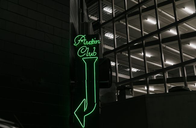 Austin Club exterior neon green sign.