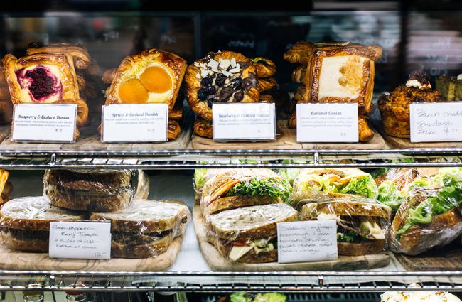 Pastries and sandwiches in the cabinet.