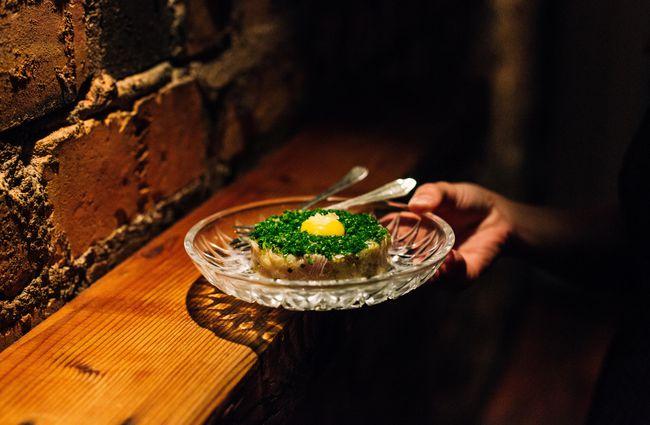Someone holding a dish of beef tartare at Bar Celeste.