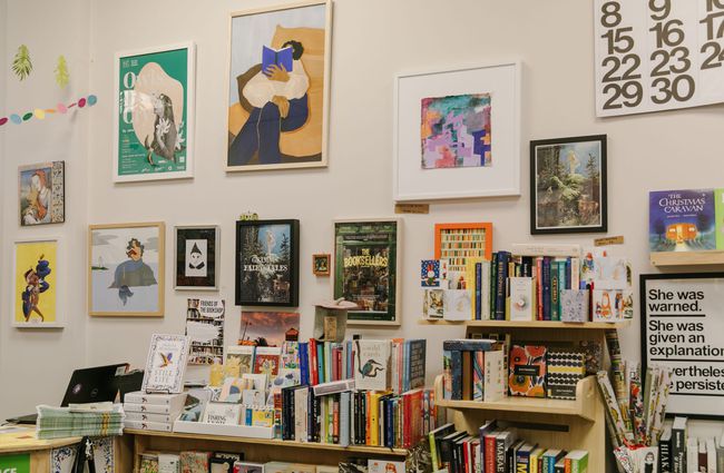 A bunch of framed artwork on the wall at Bay Hills Books in Timaru, New Zealand.