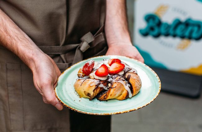 Person holding a vegan pastry with strawberries at Belén, Wellington.
