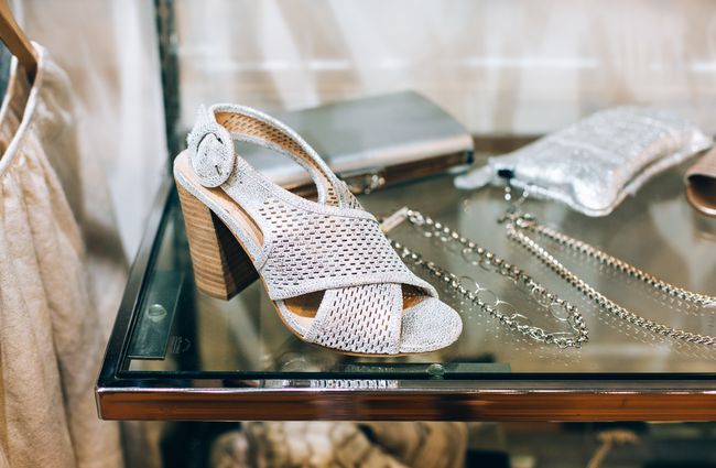 White shoe on a shelf with some jewellery.