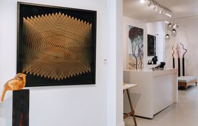 Various artworks on display including a glass bird in the foreground at Black Door Gallery, Auckland.