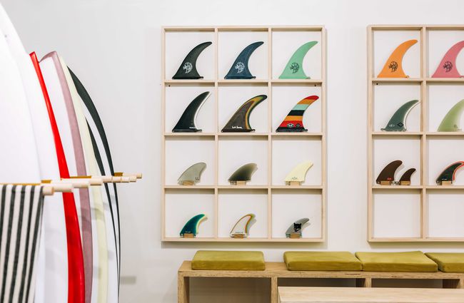 Surfboard fins on display against a white wall.