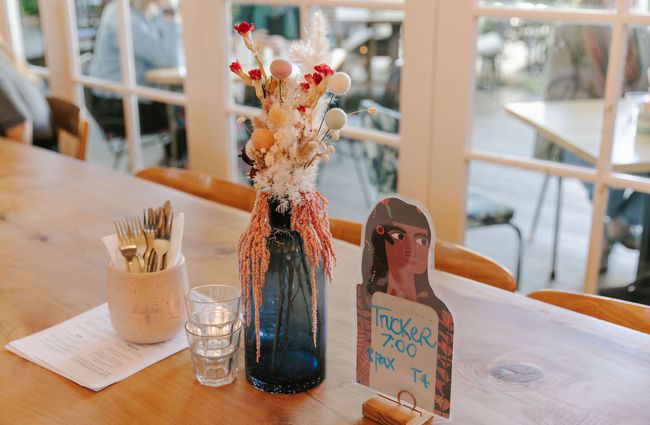 Flower vase with dried flowers and cutlery pot on a table at Bloom Cafe, Motueka.