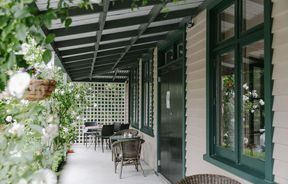 A covered verandah outside Cafe Verde, surrounded by greenery in Geraldine.