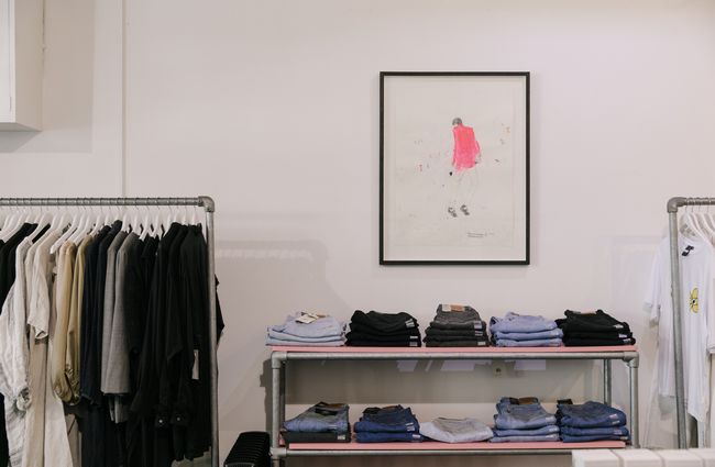 Artwork on the wall, and clothing racks at Company for Strangers.