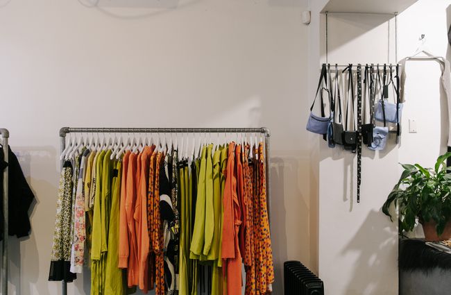 Orange and yellow hued clothing on a rack at Company for Strangers.