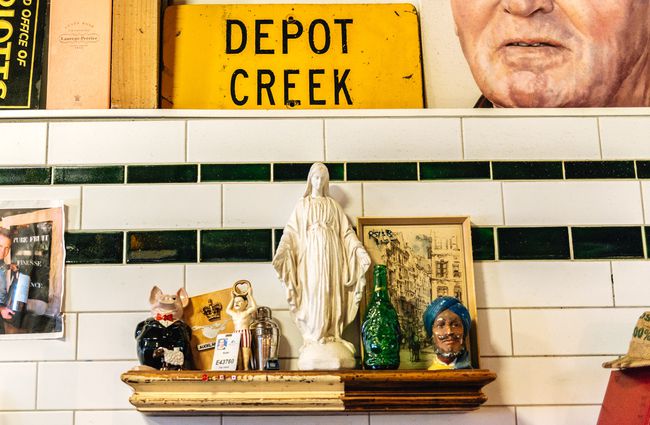 Shelf in front of white tiles and a yellow depot sign.