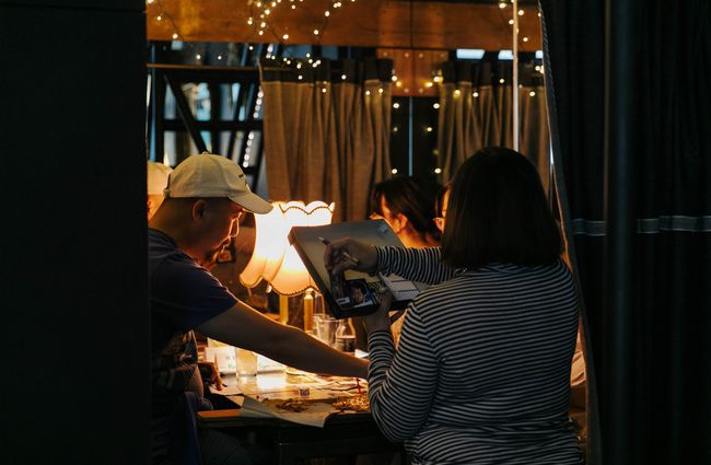 Two people playing a game under fairy lights at Dice and Slice in Christchurch.