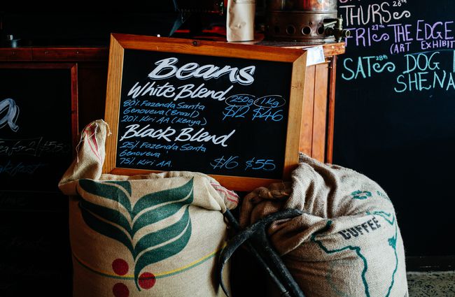 Blackboard sign on top of bags of beans.