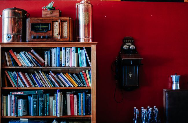 Bookshelf against a red wall.