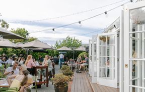 Bi-fold white doors onto deck and courtyard area of Dux Dine in Christchurch.