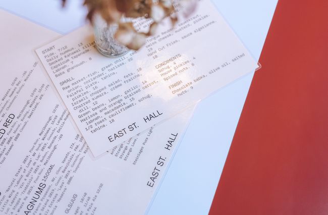 Close up of plastic covered white and black menus on a table.