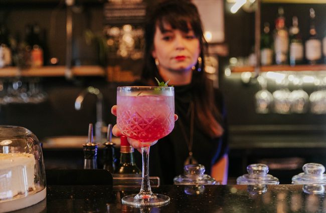 Woman making cocktail on a bar at Evil Genius Bar and Eatery in Christchurch.