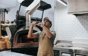 A chef making pizza at Fire and Slice woodfired pizza in Sumner.