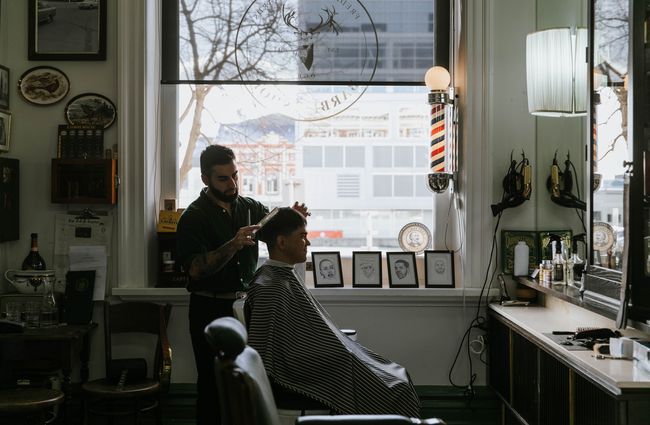 A barber cutting hair at Frederick Woodward's Barber Shop in Christchurch.