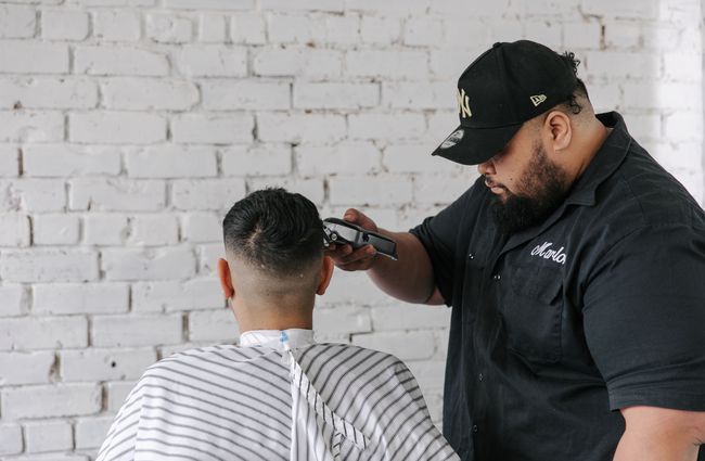 Close up of a man getting his haircut with clippers.