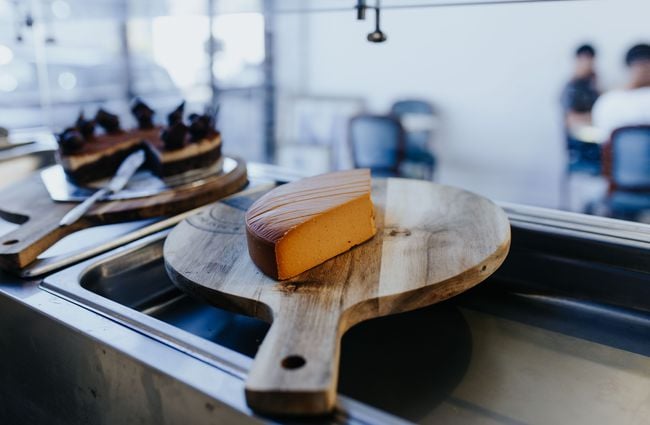Wedge of cheese on a wooden board.