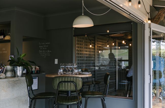 Dining table with green leather chairs at Greystone Wines, North Canterbury.
