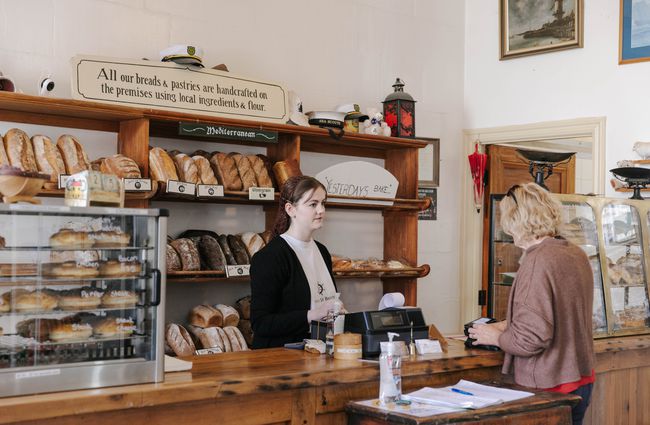 Woman serving a customer at the bakery at Deja Moo & Harbour Street Bakery in Ōamaru.