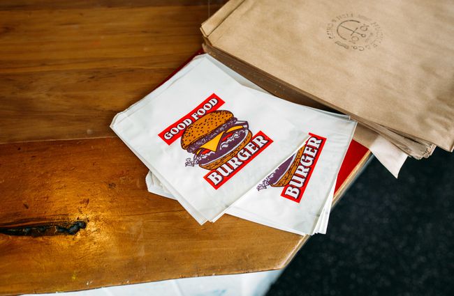 Close up of a paper bag with a burger printed on it.