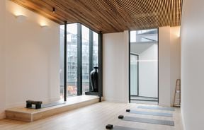 An empty yoga studio with sunlight streaming through the windows.