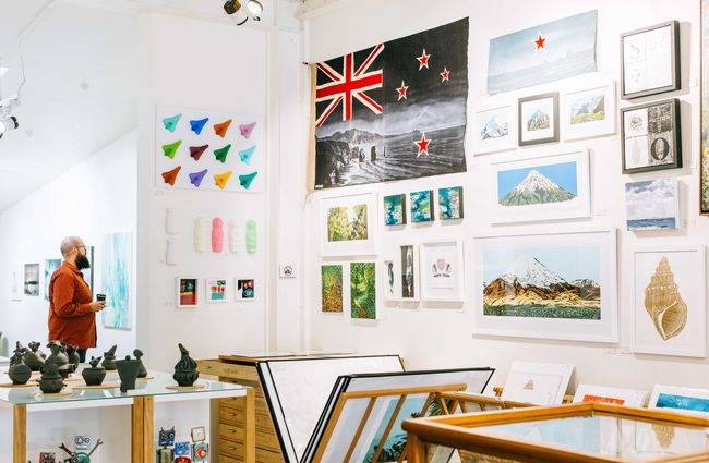 A range of artworks framed on the wall at Kina NZ Design + Artspace, New Plymouth.