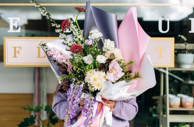 Woman holding a bouquet from Le Fleur.