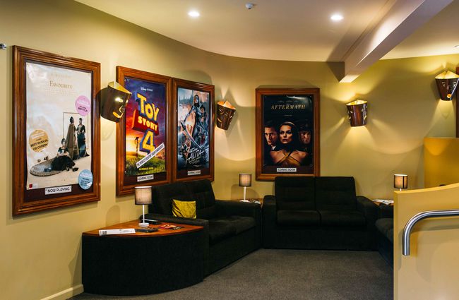 Darkened lobby with cinema posters on the wall.