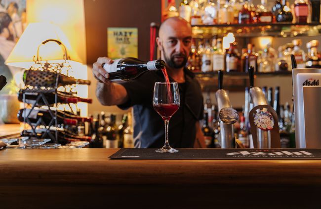 Man pouring a glass of red wine.