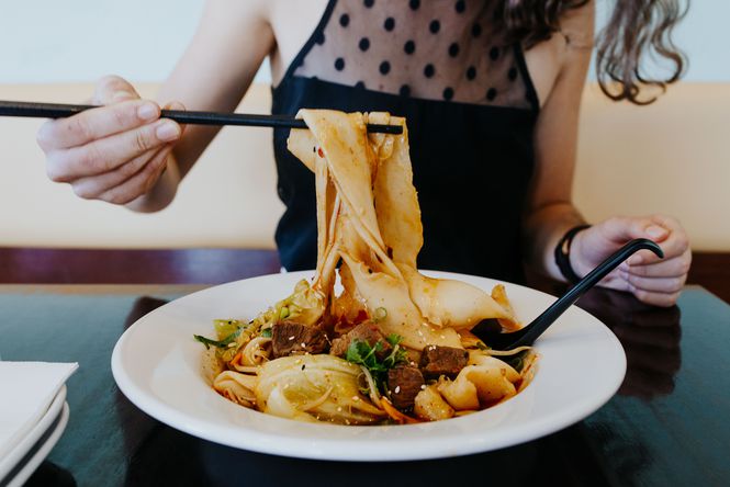 Plate of noodles being eaten with chopsticks at Miss Peppercorn in Sumner.