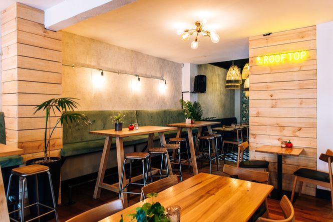 Large restaurant space downstairs with wooden walls and colourful seating.