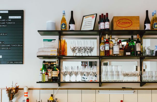 Shelves behind the bar with glasses and bottles of spirits at Next Door, Wellington.