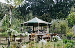 A yurt surrounded by tables and chairs at Okuti Garden in Little River.