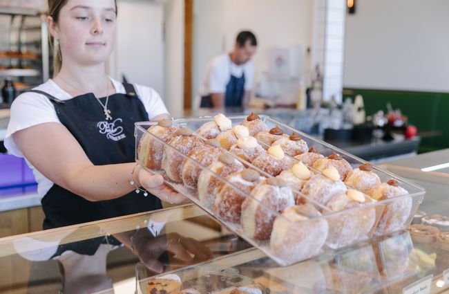 Woman holding selection of donuts at Pembroke Patisserie, Wānaka.