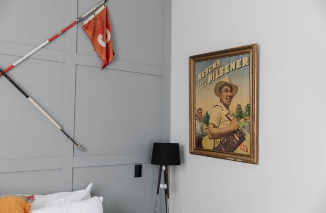 Close up of room interior with flag and framed picture at Poshtel in Ōamaru.