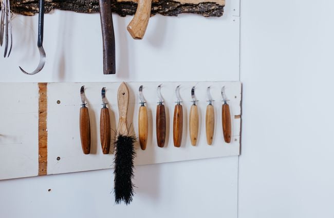 Items made of wood hanging on a white wall.