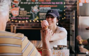Woman handing customer an ice cream.