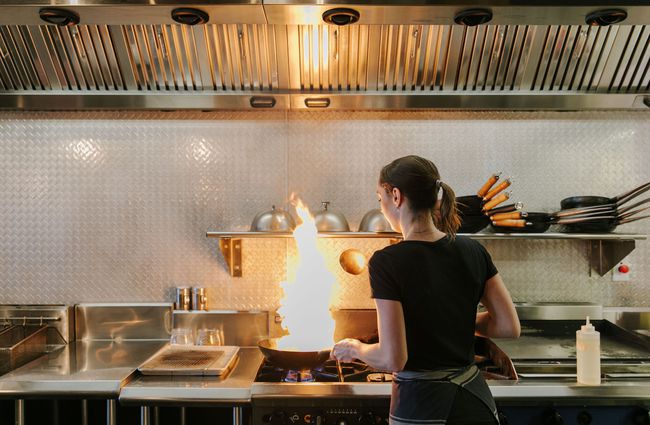Chef in the kitchen with flaming frying pan at Saikou, Timaru.