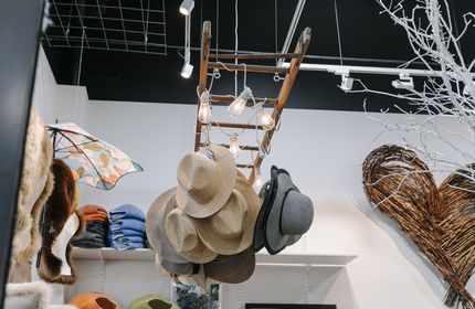 A bunch of hats suspended from the ceiling at Shopology.