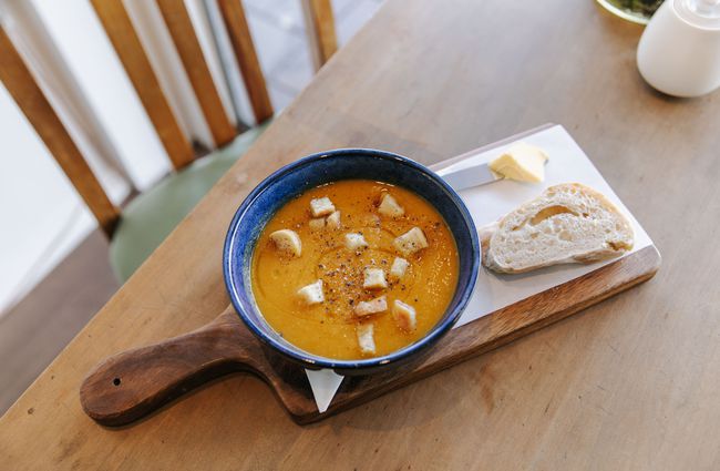 Bowl of soup and bread on a table at Six Ounces.
