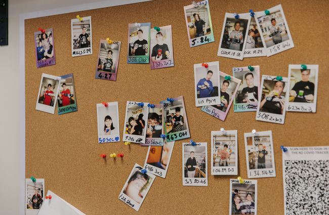 Pinboard of polaroids showing speedcube record holders.
